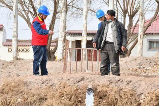 国网吐鲁番供电公司党员服务队为村民灌溉设备送电。李刚 摄