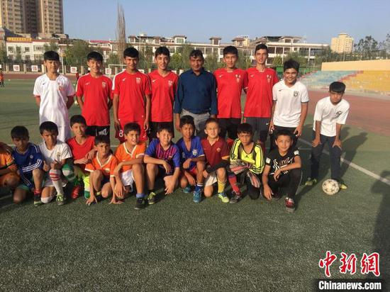 2023年U20中国男足队员木塔力普·依敏卡日、西尔杂提·努尔在喀什市夏马勒巴格镇中心小学。资料图。　买买提江·马哈木提 摄
