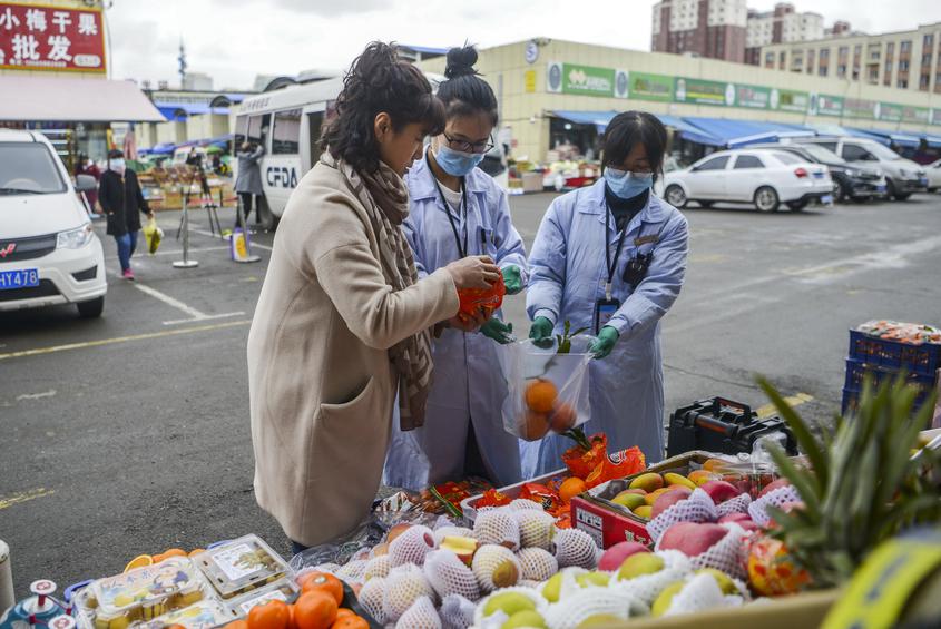 热心市民参与其中，从水果摊上随意选取农产品进行检测。