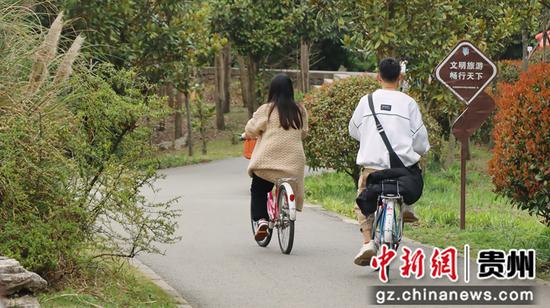 市民在贵阳市花溪区十里河滩骑自行车。
