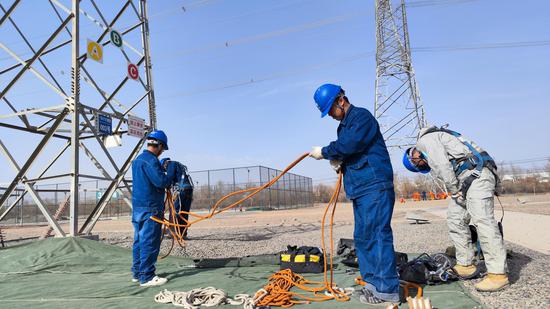 3月15日，国网吐鲁番供电公司输电运检技能人员在开展岗位晋升实操考试带电作业项目地面准备工作。何重凯 摄