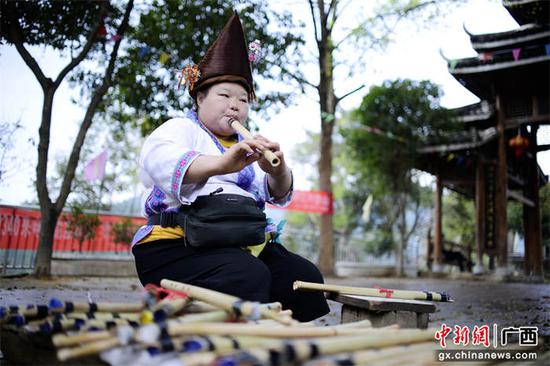 图为元江春社坡会上，一名苗族妇女正在吹奏苗笛。兰堃  摄