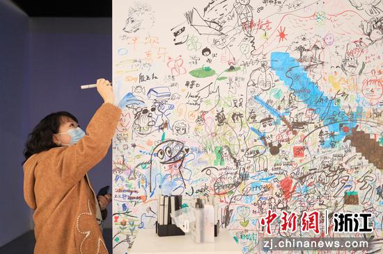 观众在展览涂鸦墙上自由创作。  徐梓齐（实习生） 摄