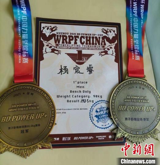 图为杨宸睿参加力量举比赛获得的证书和奖章。　受访者供图