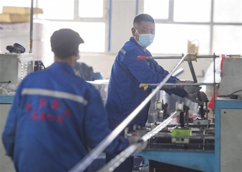 3月10日，昌吉市大西渠镇天力塑料品厂生产车间，员工在滴灌带生产线作业。 何龙 摄

