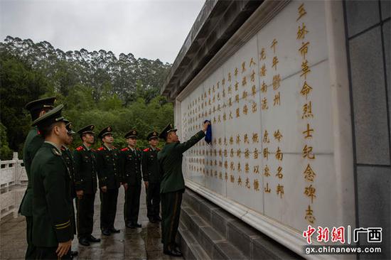 3月31日，武警官兵在仪式现场后擦拭英雄纪念碑。武警玉林支队供图