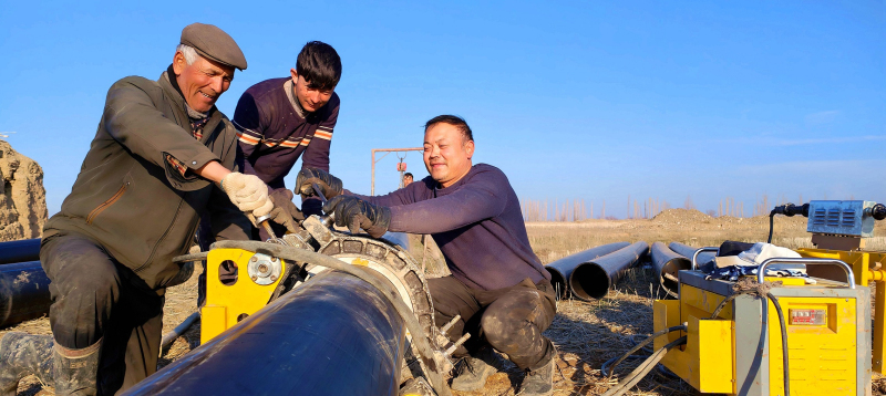 4月4日，在新疆伊犁哈萨克自治州察布查尔锡伯自治县加尕斯台镇高标准农田建设施工现场，施工人员正忙着焊接输水管。华岩明摄 