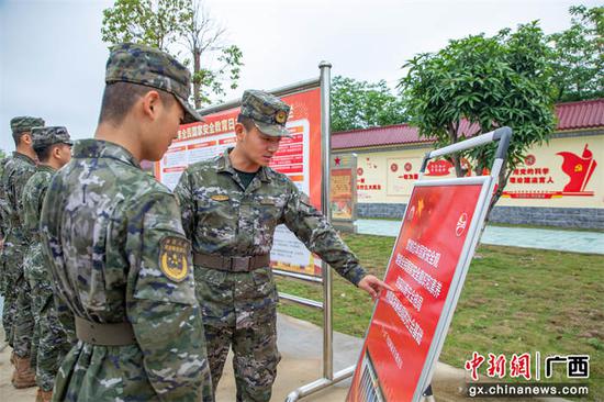 4月11日，武警官兵利用展板挂图，学习国家安全知识。