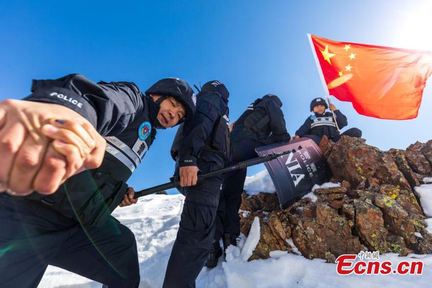 Police officers walk hand-in-hand on a snow-covered mountain to patrol the border area more than 3,600 above sea level in northwest China's Xinjiang Uyghur Autonomous Region, April 9, 2023. (Photo: China News Service/Lv Zhiheng)

