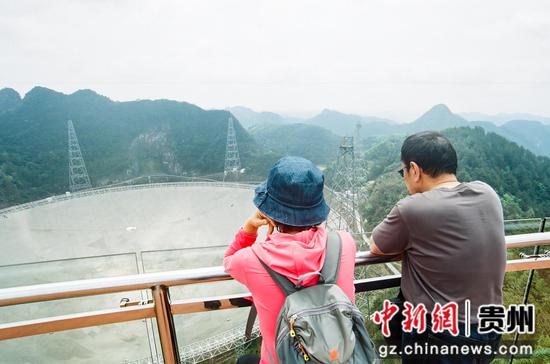 4月11日，两位访客在瞭望台远眺“中国天眼”全貌。瞿宏伦 摄