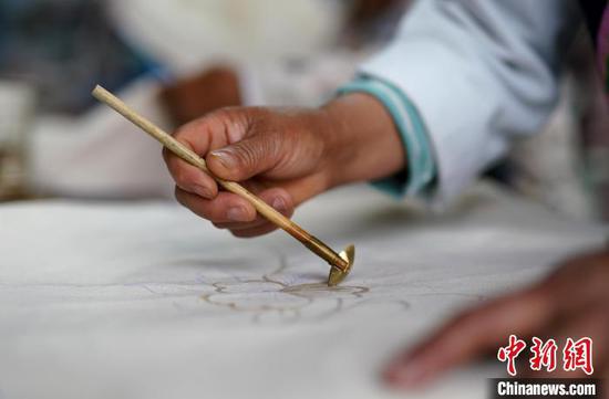 苗族妇女在贵州丹寨县龙泉镇卡拉村蜡染工坊绘制蜡画。　黄晓海 摄