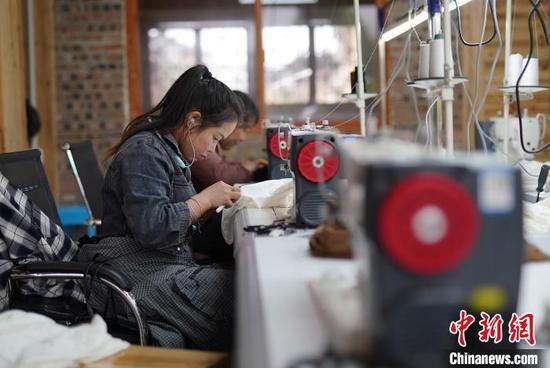 4月17日，在贵州丹寨县龙泉镇卡拉村刺绣工坊，工人在缝制手工绣品。　黄晓海 摄