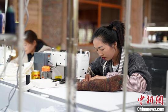 4月17日，在贵州丹寨县龙泉镇卡拉村刺绣工坊，工人在缝制手工绣品。　黄晓海 摄