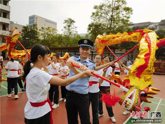 图为友谊关边检站移民管理警察和师生一同舞龙。罗晓  摄