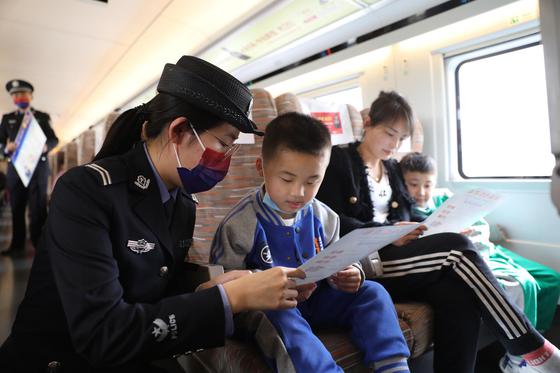 乘警为旅客讲解铁路安全知识。 北京铁路局天津公安处供图