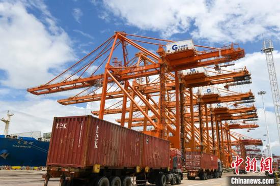西部陆海新通道重要节点广西钦州港码头卡车在排队运输集装箱。王以照 摄
