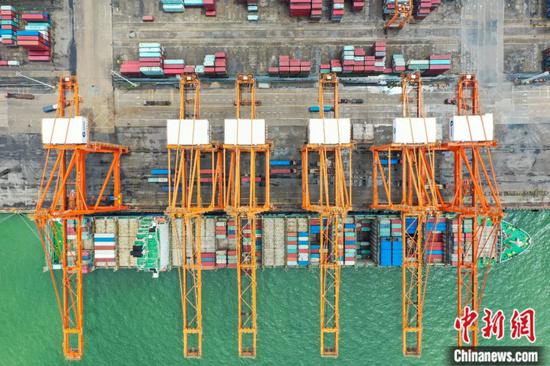 西部陆海新通道重要节点广西钦州港码头货轮靠泊码头装运集装箱。王以照 摄