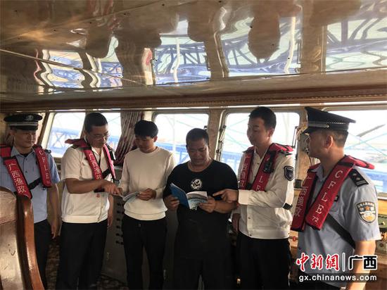 联合执法人员向渔民发放安全宣传材料。广西渔政执法总队供图