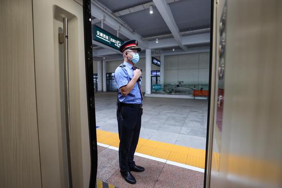 G5344次列车列车长郑川东在安顺西站确认旅客上车完毕。 瞿宏伦 摄