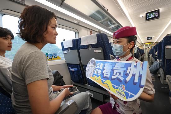 G5344次列车列车员武梦怡在给旅客介绍“坐着高铁看贵州”主题宣传活动。 瞿宏伦 摄