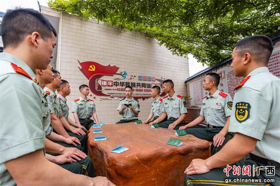 少尉排长陈柏宇组织团员重温学习中国共产主义青年团章程并填写团员证。武警玉林支队陆川中队供图