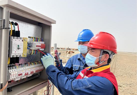 国网叶城县供电公司员工在华凌产业园检查牛业田园综合体饮水配电箱。买尔哈巴·米吉提 摄