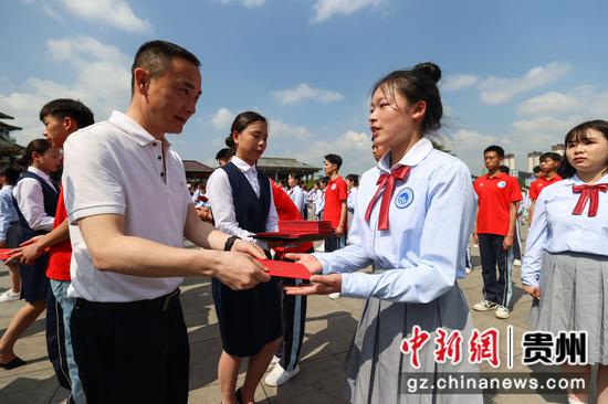 图为一名学生代表从嘉宾手中接过成人礼证书。 瞿宏伦 摄