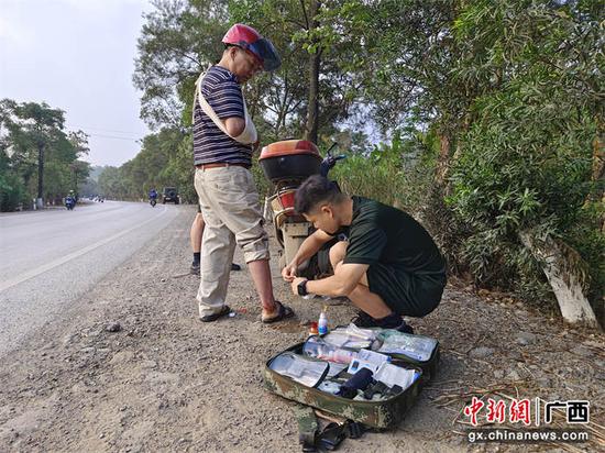 图为武警官兵为摔伤老人进行消毒止血。高明 摄 图为武警官兵为摔伤老人进行消毒止血。高明 摄
