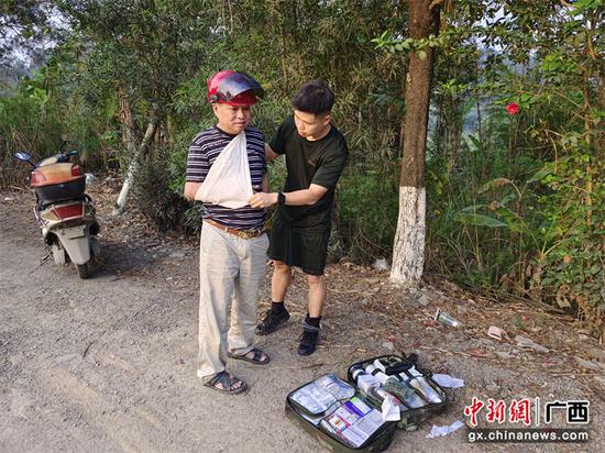 图为武警官兵为摔伤老人进行固定包扎。高明 摄