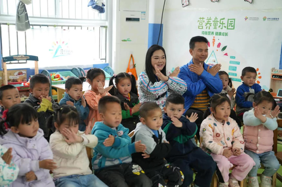 爱心人士孙东先生、梁丁苏女士和孩子们一起上营养健康课程