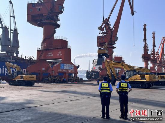 边检民警监护重型机械吊装上船。广西钦州保税港区出入境边防检查站