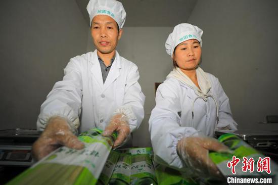 工人在贵州省江口县双江街道一家食品加工企业为抹茶面条装袋。　李鹤 摄