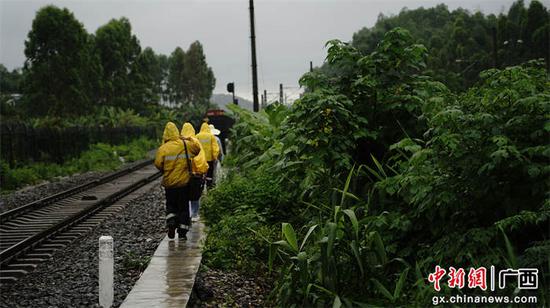 图为玉林工务段职工徒步冒雨巡查线路检查遭遇强降雨袭击情况。谭育俊  摄