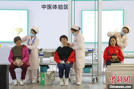 参观者在广东省中医院贵州医院展区设置的中医体验区体验。　瞿宏伦 摄
