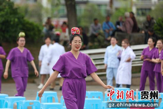 2023年5月12日，贵州省黔东南苗族侗族自治州施秉县妇幼保健院的护士在进行头顶沙包接力赛活动。磨桂宾 摄