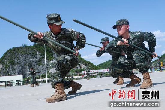 图为班长正在向新兵传授应急棍术训练方法。黄俊 摄
