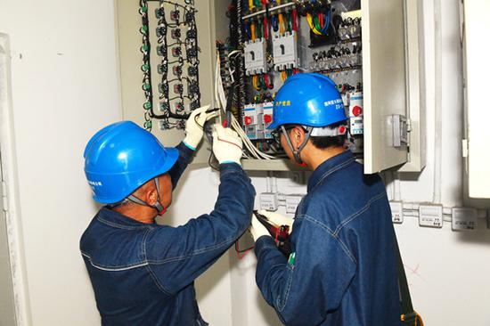 国网霍尔果斯市供电公司城区供电所员工在中哈霍尔果斯国际边境合作中心协助用户排查安全用电隐患。