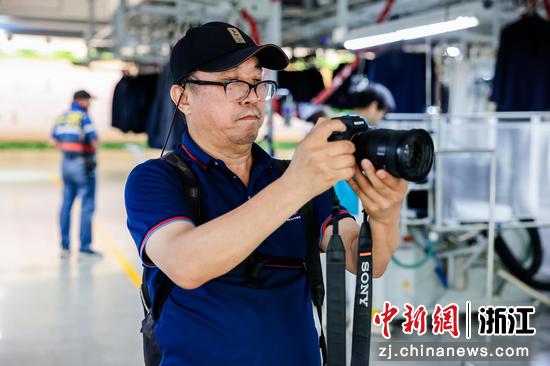 　　大型摄影专题《希望工程》作者、中国摄影金像奖获 得者解海龙在雅戈尔5G智能车间采风创作。 主办方供图