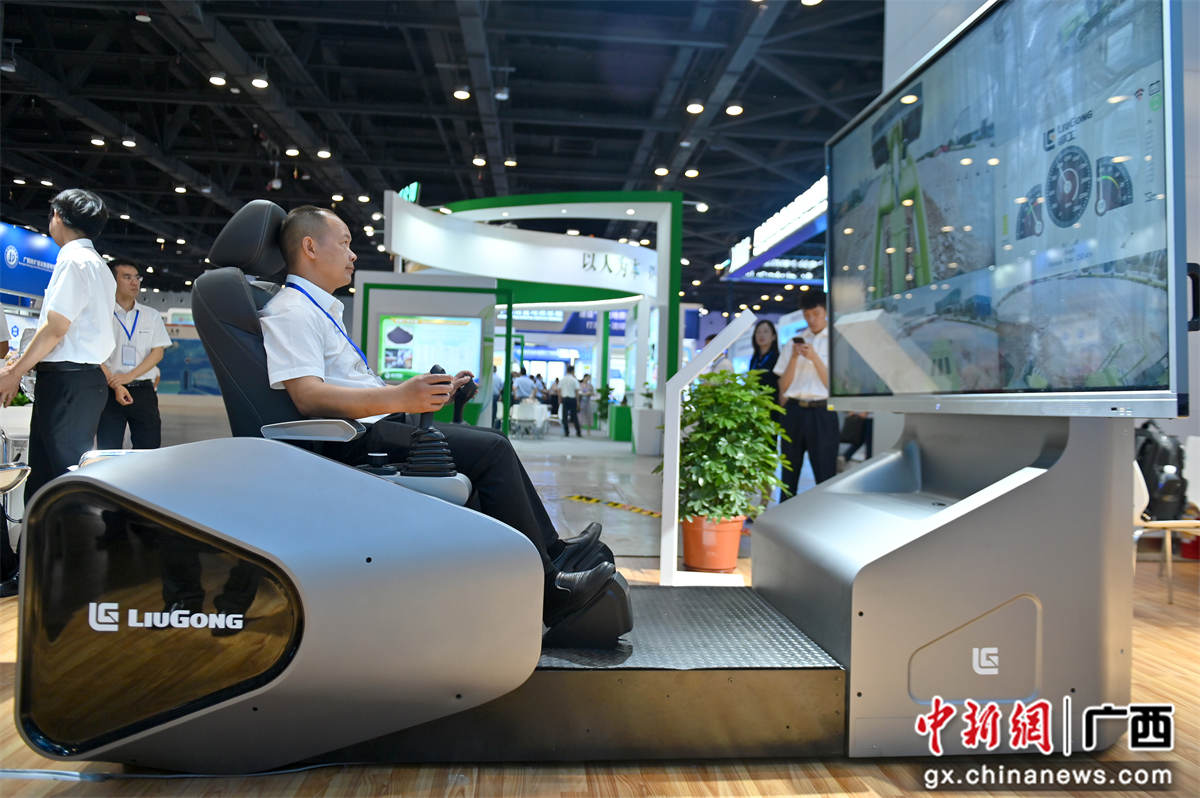 5月18日，一參展商展示操作5G智能遙控電動裝載機。該機器利用5G技術(shù)，實現(xiàn)人車分離，可應(yīng)對高溫高危等惡劣工況。當(dāng)天，2023（第十二屆）中國—東盟礦業(yè)合作論壇暨推介展示會在南寧國際會展中心開幕。俞靖  攝
