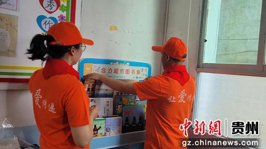合力超市集团志愿者为图书角贴角标 合力超市集团志愿者为图书角贴角标