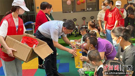南宁市残疾人联合会党组成员、副理事长黄长志给特殊儿童送微心愿爱心礼物。滕美专  摄