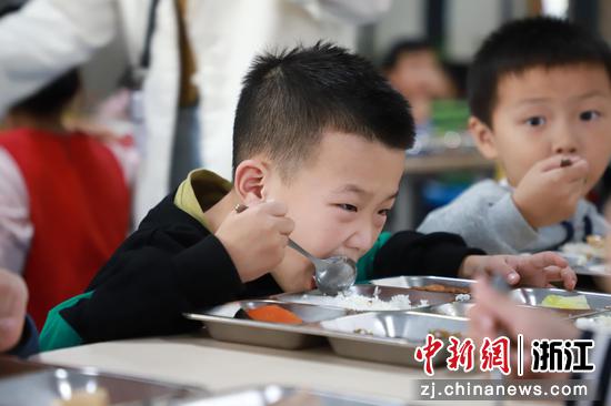 当地一名儿童正在学校就餐。 
 临平区供图