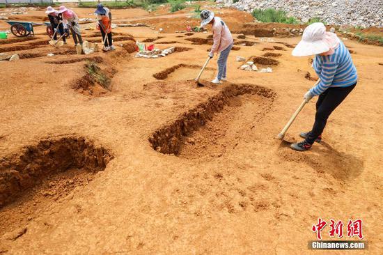 5月24日，工作人员在大松山墓群挖掘区域对地表进行刮面作业。