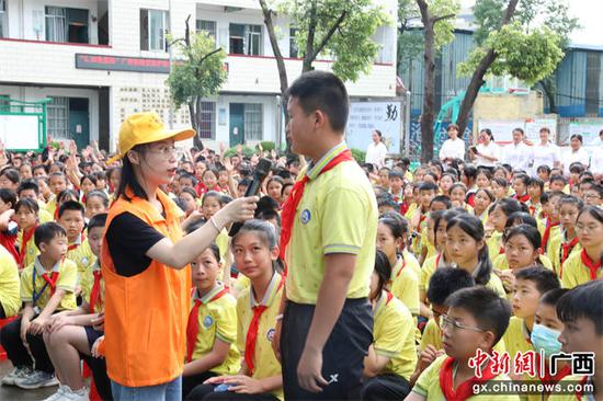 宁铁青年志愿者欧贝贝与学生开展爱路护路知识问答。冷鹏飞 摄