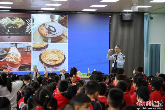 广西贵港市市场监管局工作人员为小朋友讲解食品安全知识。韦慧玲摄