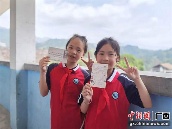 图为高定小学学生收到了南宁边检站民警的明信片，开心地对着镜头展示。 陆东  摄