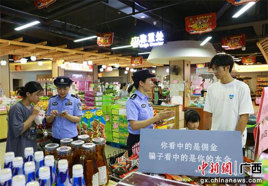 图为6月1日，该局反诈中心和西湾派出所民警在超市向购物群众进行反诈宣传。甘勇 摄