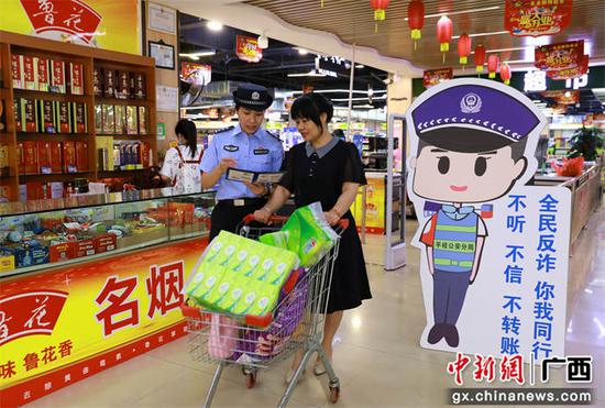 图为该局反诈中心和西湾派出所民警在超市向购物群众进行反诈宣传。甘勇 摄