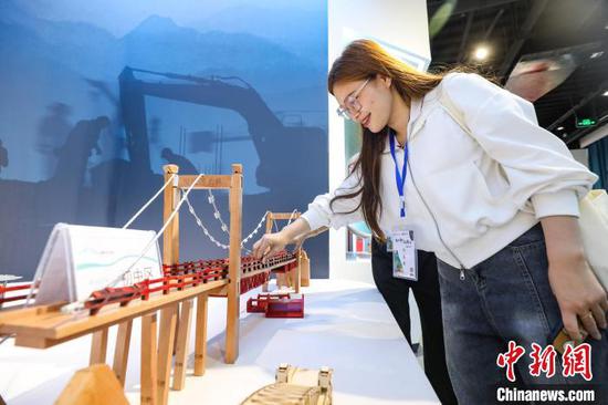6月3日，一名留学生在贵州省坝陵河桥梁博物馆参观桥梁模型。　中新社记者 瞿宏伦 摄