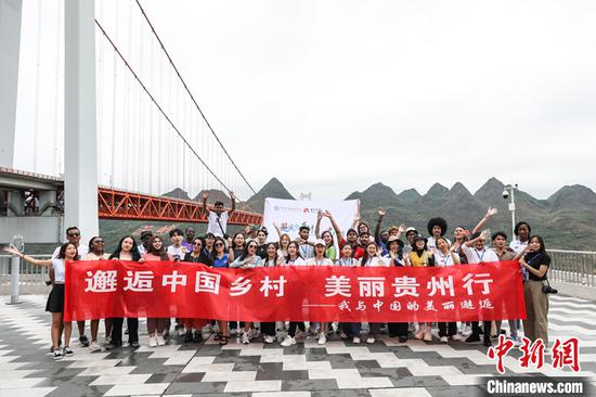 图为留学生们以坝陵河大桥为背景合影。 中新社记者 瞿宏伦 摄